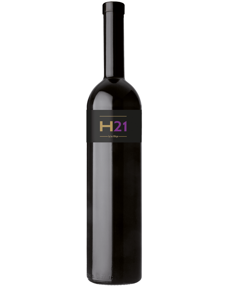 Rotwein Cuvée H21 von Leo Hillinger in einem Weinglas, dunkle Trauben und elegantes Weinglas auf einem Holztisch.